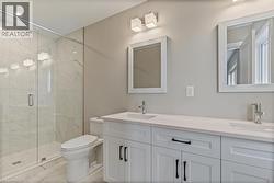 Full bath with a marble finish shower, double vanity, and light marble finish floors -