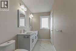 Bathroom with light marble finish floors and double vanity -