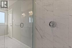 Bathroom with a marble finish shower and marble finish floors -