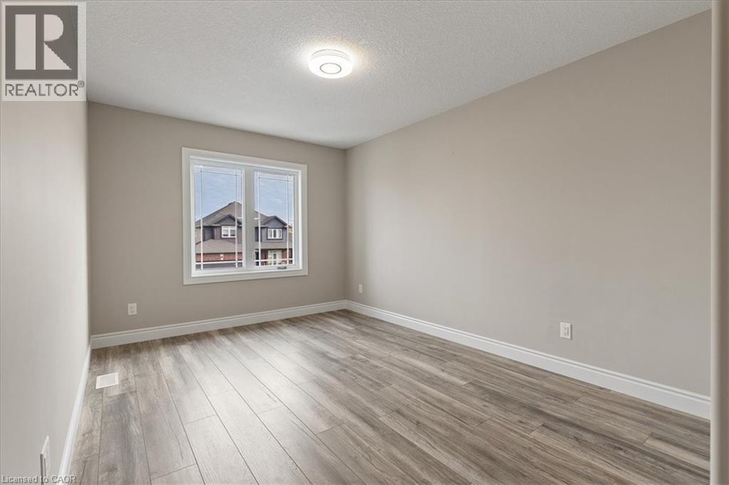 Spare room featuring light wood-type flooring and a textured ceiling - 256 Keeso Lane, Listowel, ON - Indoor Photo Showing Other Room