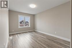 Spare room featuring light wood-type flooring and a textured ceiling -