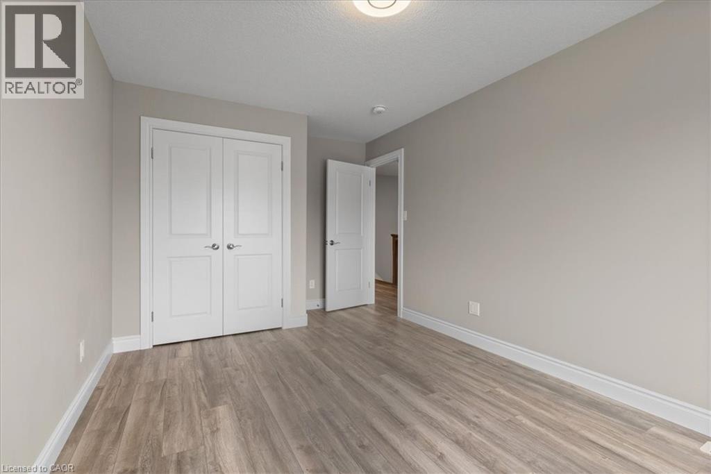 Unfurnished bedroom with light wood-style floors, a closet, and a textured ceiling - 256 Keeso Lane, Listowel, ON - Indoor Photo Showing Other Room