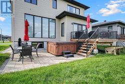 Deck leads to stone patio w/hot tub. -