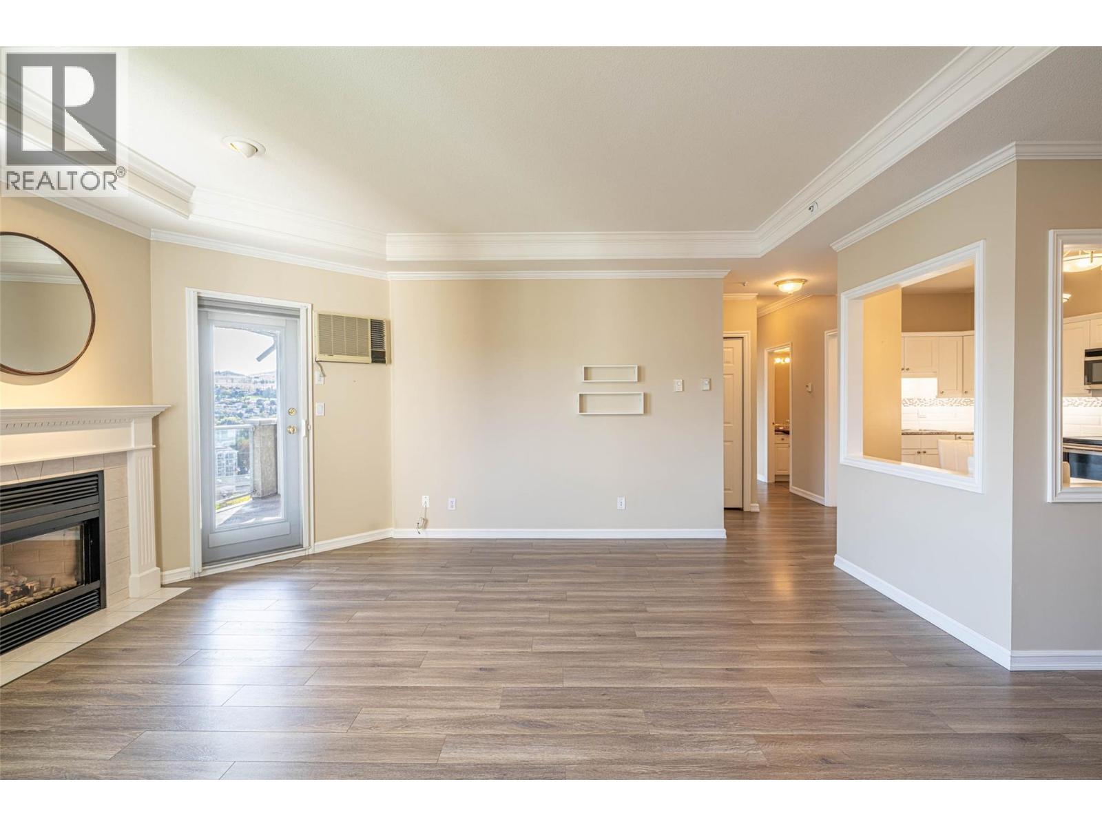 Living room looking towards the kitchen and french door to the covered balcony - 3300 Centennial Drive Unit# 411, Vernon, BC - Indoor Photo Showing Living Room With Fireplace