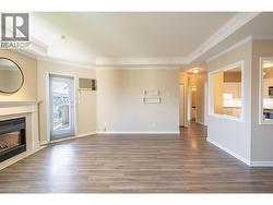 Living room looking towards the kitchen and french door to the covered balcony -