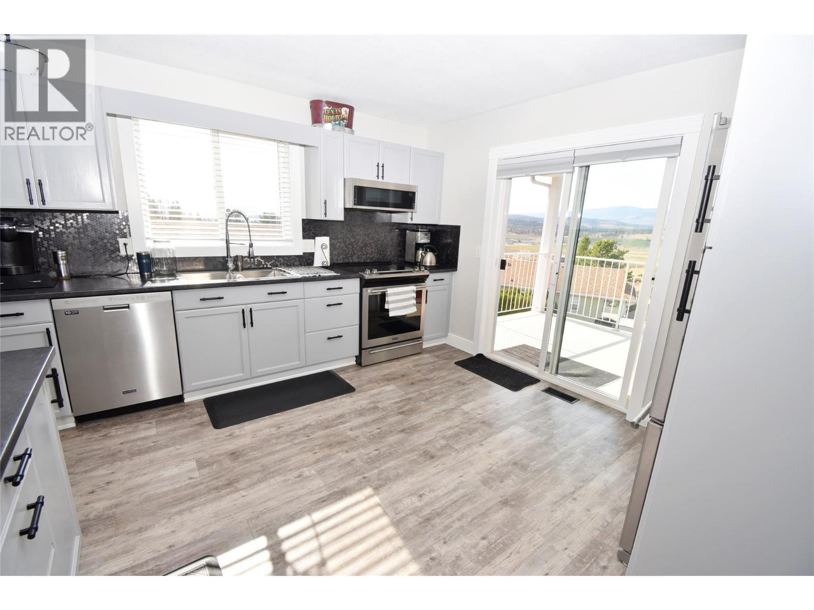 Sliding doors to back deck from kitchen - 6427 Spencer Road, Kelowna, BC - Indoor Photo Showing Kitchen