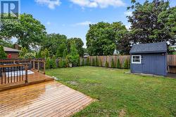 Rear yard with deck, greenspace and storage. -