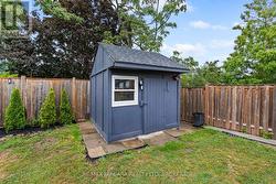 Rear yard with deck, greenspace and storage. -