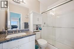 Full bath featuring a chandelier, a shower stall, vanity, and ensuite bathroom -