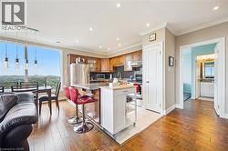 Kitchen with a kitchen bar, stainless steel appliances, light wood finished floors, backsplash, and recessed lighting -