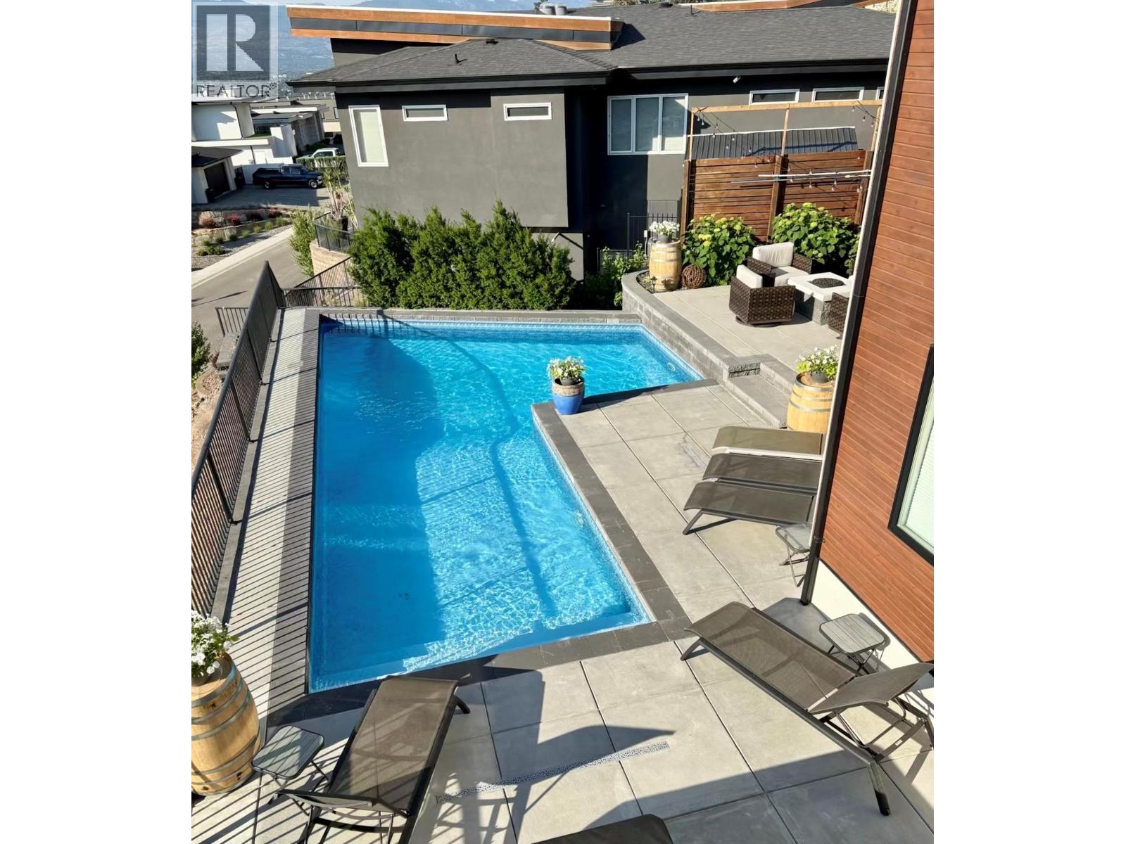 View of custom size, salt water pool from main floor deck - 738 Highpointe Drive, Kelowna, BC - Outdoor With In Ground Pool
