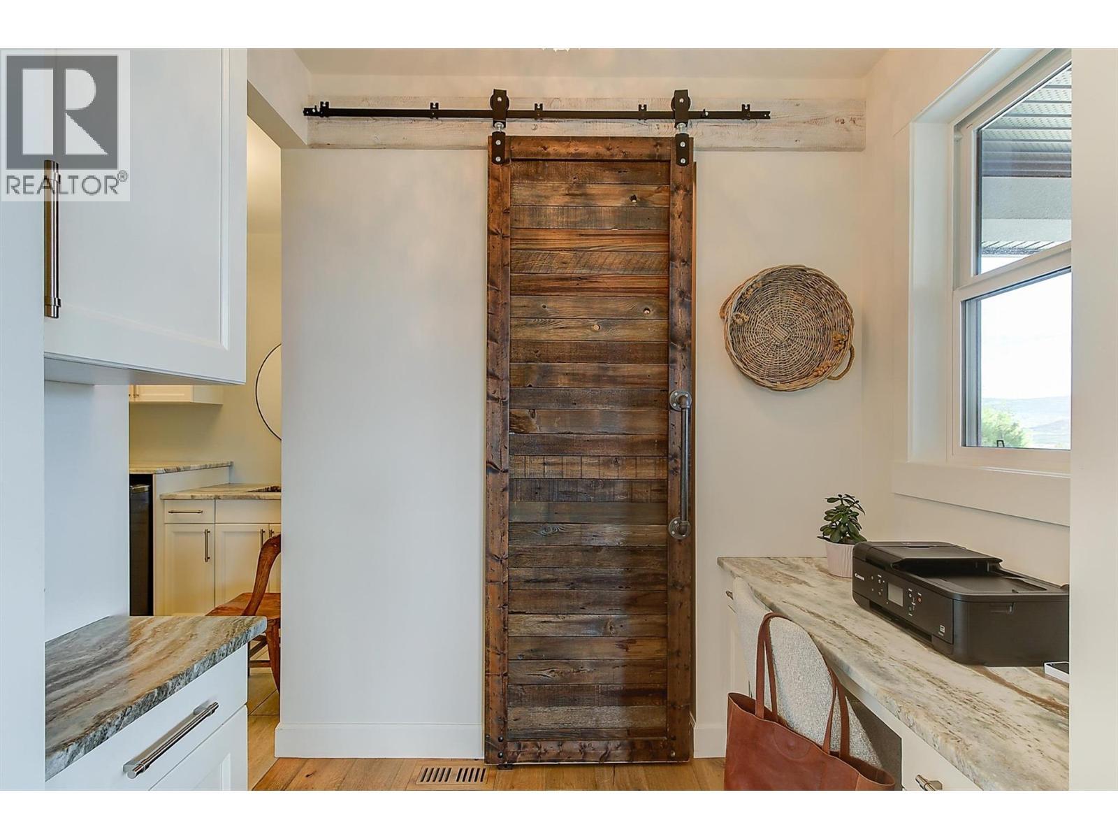 The pantry showcases built-in wood shelving and a rustic sliding barn door - 738 Highpointe Drive, Kelowna, BC - Indoor