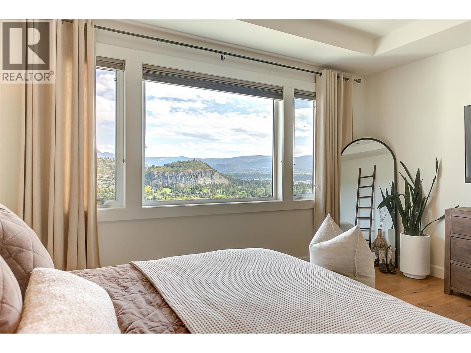 East-facing windows with mountain and valley views - 738 Highpointe Drive, Kelowna, BC - Indoor Photo Showing Bedroom