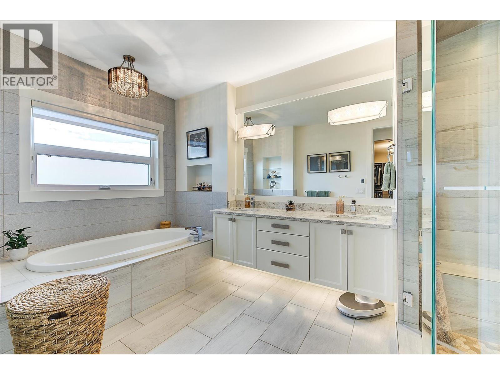A luxurious five-piece ensuite with heated floors, dual vanities, shower and a separate soaker tub. - 738 Highpointe Drive, Kelowna, BC - Indoor Photo Showing Bathroom
