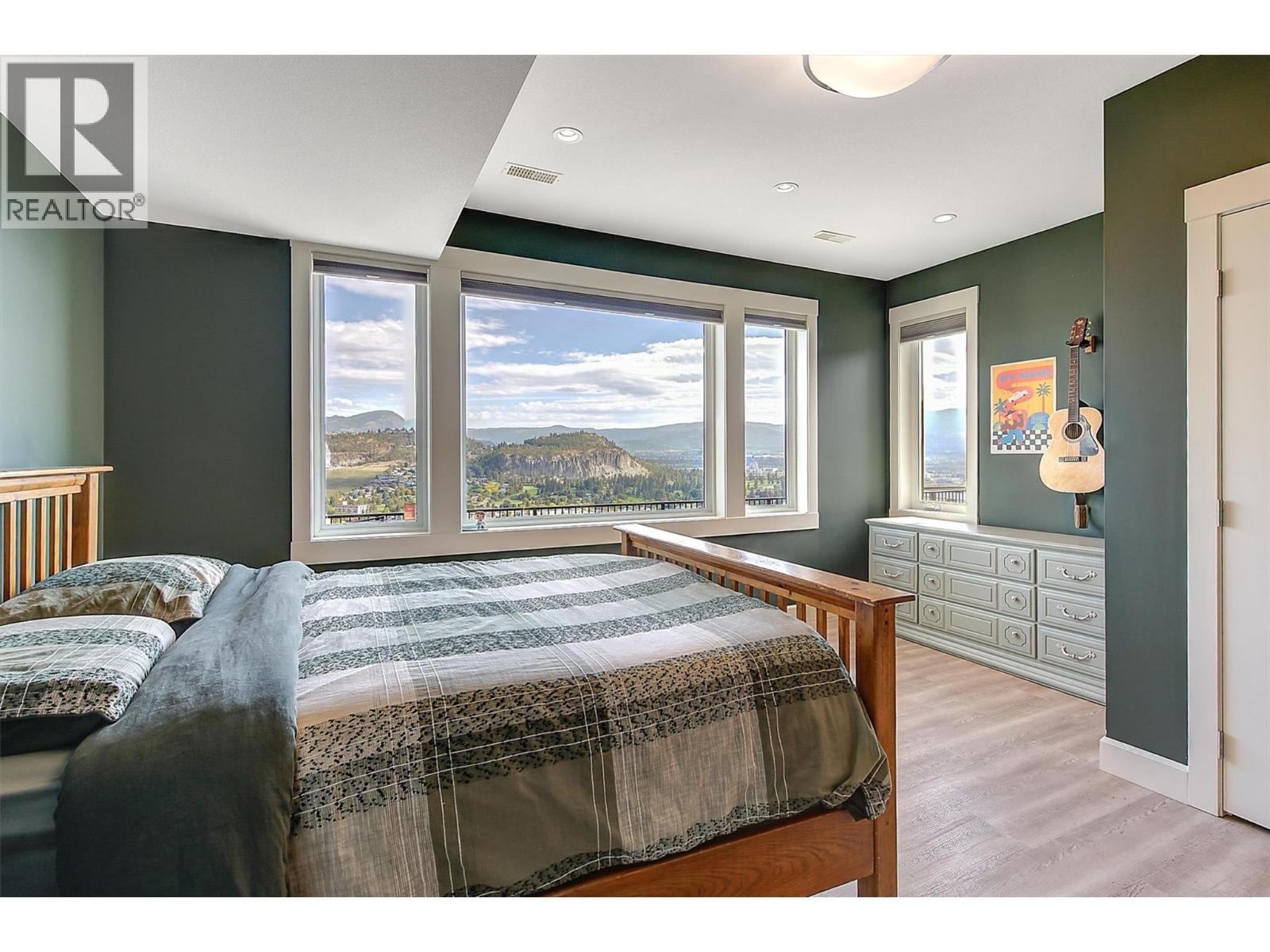 1st lower level bedroom - east-facing windows overlooking the backyard and pool deck - 738 Highpointe Drive, Kelowna, BC - Indoor Photo Showing Bedroom