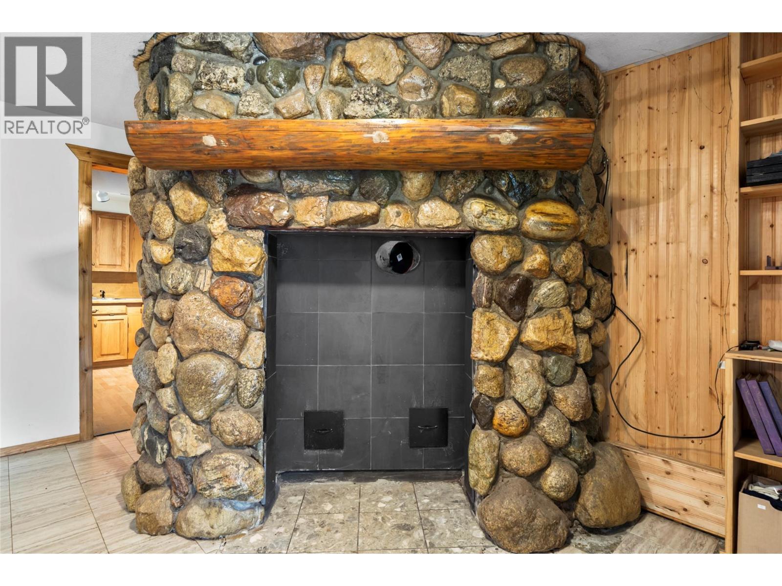 Rock fire place that extends all 3 levels - 2462 Leisure Road, Blind Bay, BC - Indoor With Fireplace