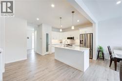 Kitchen with stainless steel appliances, pendant lighting, backsplash, a kitchen island with sink, and recessed lighting -