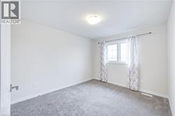 Empty room featuring carpet flooring and baseboards -