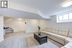 Carpeted living room with an office area and baseboards -