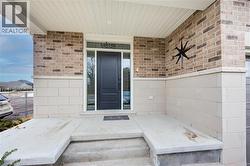 Doorway to property featuring a porch and brick siding -