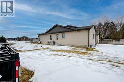 Snow covered rear of property featuring brick siding -