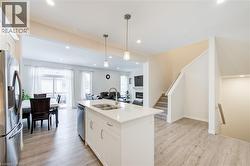 Kitchen with white cabinets, stainless steel appliances, open floor plan, recessed lighting, and a kitchen island with sink -