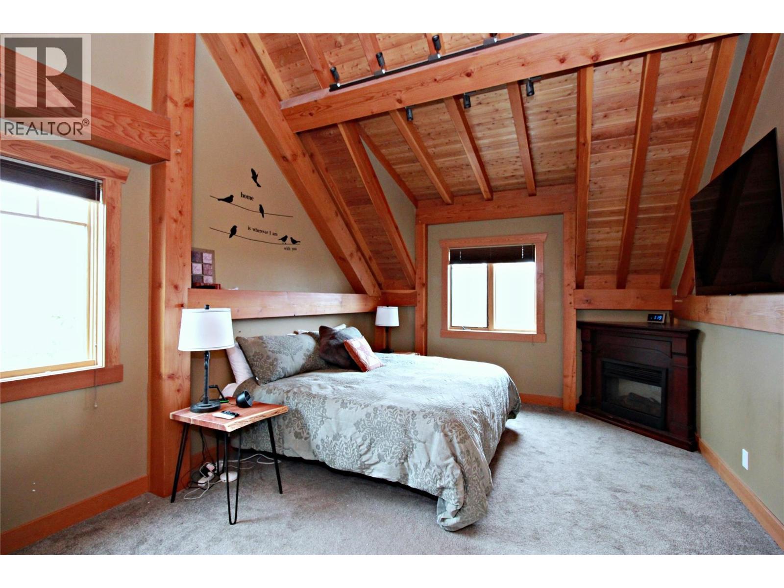 127 Grizzly Place, Castlegar, BC - Indoor Photo Showing Bedroom With Fireplace