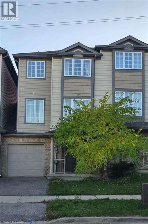 View of front of house with driveway, an attached garage, and stone siding - 42 Tudor Street, Kitchener, ON - Outdoor With Facade