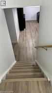 Stairway with wood finished floors and baseboards -