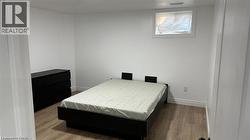 Bedroom with wood finished floors and baseboards -