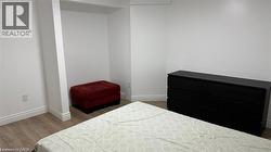 Bedroom featuring dark wood-type flooring and baseboards -