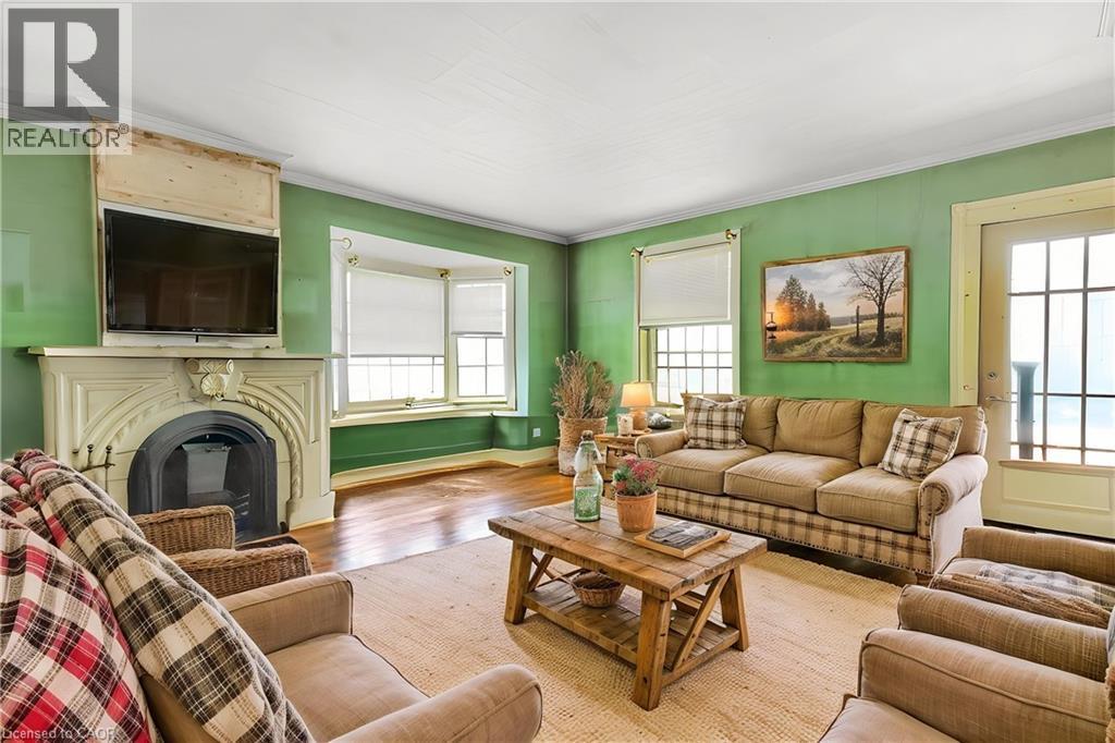Living area with crown molding, a glass covered fireplace, and wood finished floors Virtual Staged - 36 Elgin E/S Street W, Conestogo, ON - Indoor Photo Showing Living Room With Fireplace