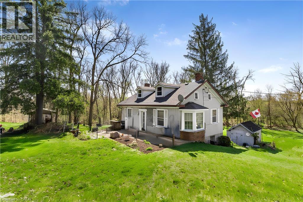 View of side of home featuring a lawn, an outbuilding, a chimney, and brick siding - 36 Elgin E/S Street W, Conestogo, ON - Outdoor