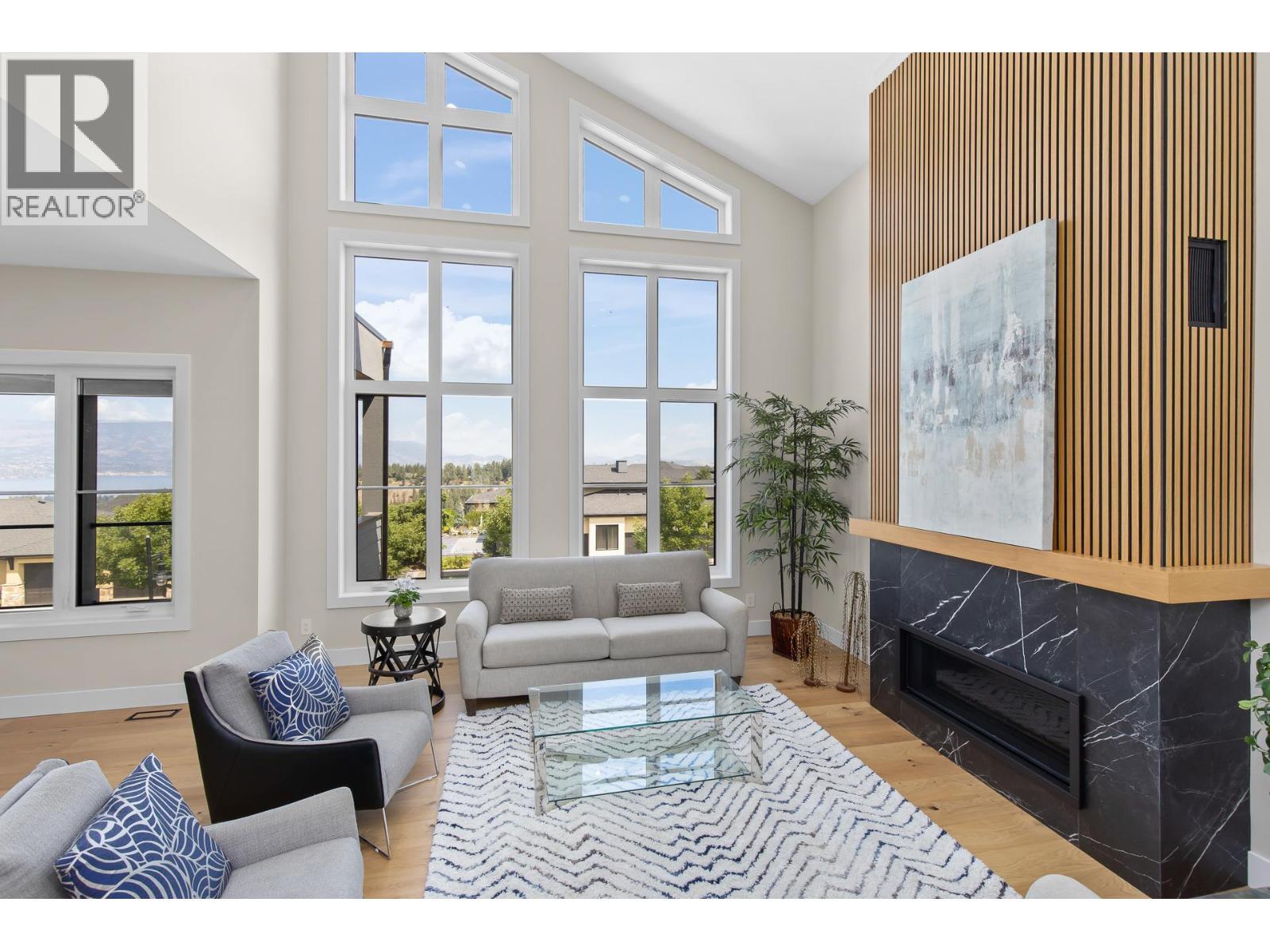 Abundance of natural light with large windows. - 4964 Bucktail Lane, Kelowna, BC - Indoor Photo Showing Living Room With Fireplace