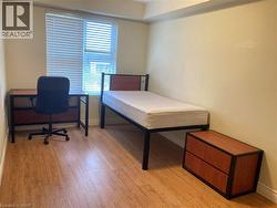 Bedroom with light wood finished floors and a desk -