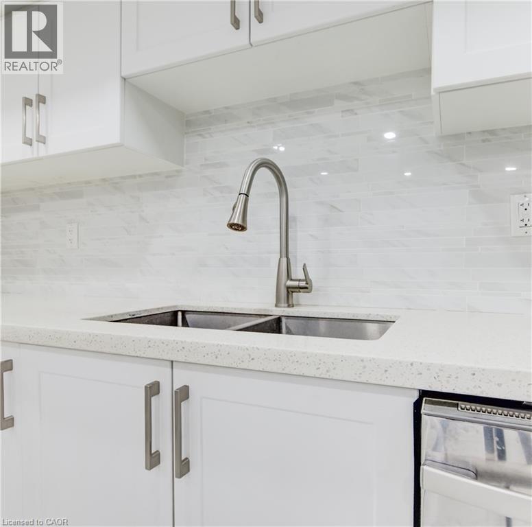 Kitchen featuring white cabinetry, decorative backsplash, light stone counters, and dishwasher - 685 Briardean Road Unit# Lower, Cambridge, ON - Indoor Photo Showing Kitchen With Double Sink With Upgraded Kitchen