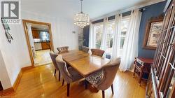 Dining room featuring light wood-style floors, a chandelier, and crown molding -