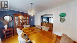 Dining room with ornamental molding, arched walkways, a chandelier, and wood finished floors -