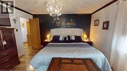 Bedroom with ornamental molding and a chandelier -