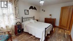 Bedroom with wood finished floors and a chandelier -