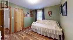 Bedroom with hardwood / wood-style floors and baseboards -