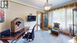 Carpeted office space featuring crown molding and baseboards -