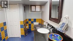 Bathroom featuring tile walls, a closet, vanity, and wainscoting -