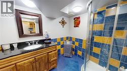 Full bathroom with a stall shower, tile walls, and vanity -