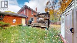 Back of property featuring a gazebo, a deck, and brick siding -