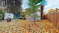 Fenced backyard featuring a deck and a shed -