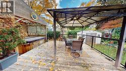 Deck with outdoor dining area, a storage unit, and a gazebo -