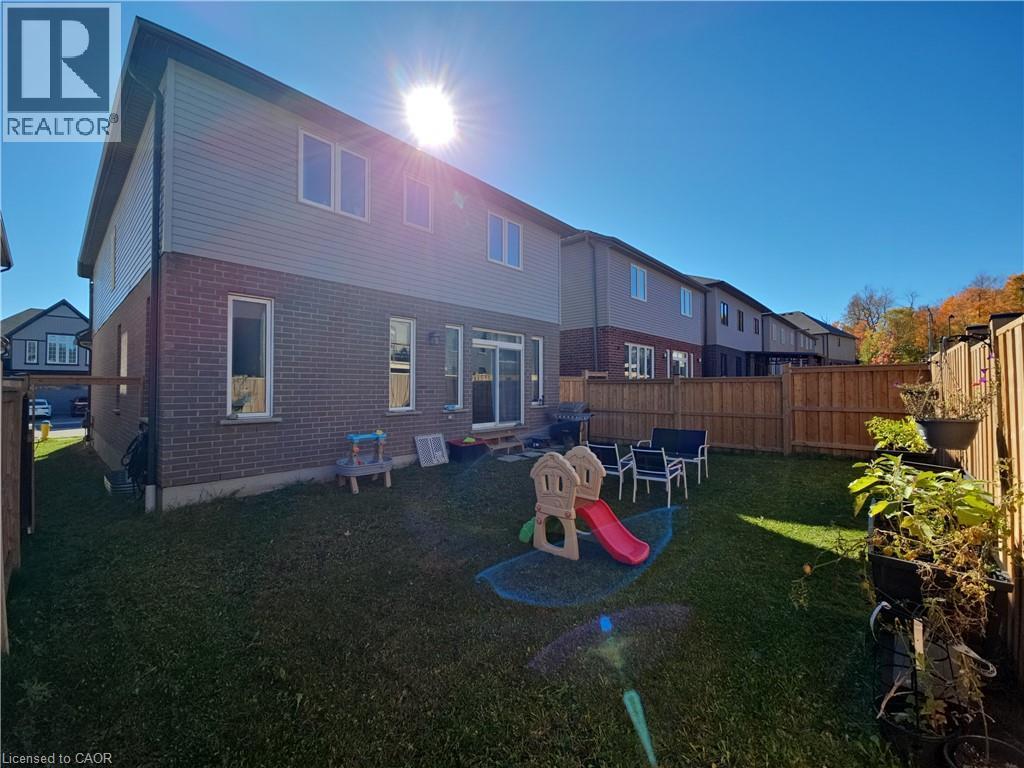 Rear view of house with brick siding and a fenced backyard - 293 Chokecherry Crescent, Waterloo, ON - Outdoor