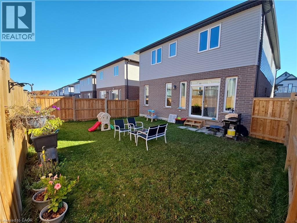 Back of property with a fenced backyard, brick siding, and a patio area - 293 Chokecherry Crescent, Waterloo, ON - Outdoor