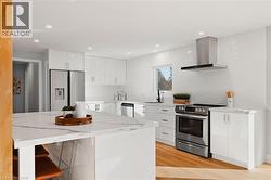 Kitchen featuring white cabinetry, modern cabinets, tasteful backsplash, appliances with stainless steel finishes, and light wood-type flooring -